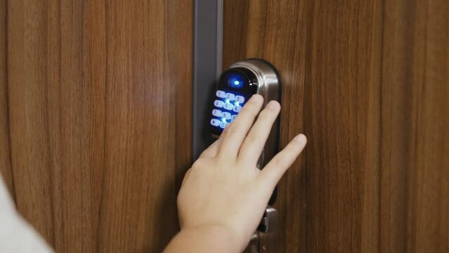 A girl friend opens the door to the apartment by dialing the code on the lock. Close-up of hands.