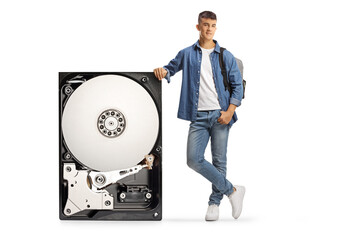 Male student leaning on a hard disk and looking at camera