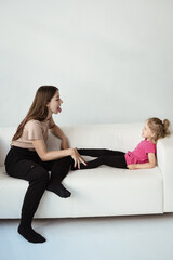 Obraz premium Speech therapist deals with a girl on a sofa in the office