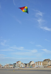 Fototapeta na wymiar Bray Dunes, France, buildings at the seafront with colorful stunt kite in the sky