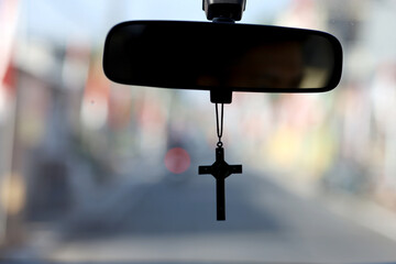 hanging a Christian cross on the rear view mirror of the car. journey with Go