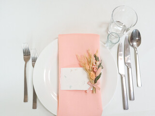 Setting the table for a wedding. An inscription card, dishes, a white tablecloth. Top view. High quality photo