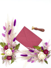 Flatley of natural flowers, burgundy envelope, seal on white background, top view, space for text. Decor, welcome card. High quality photo