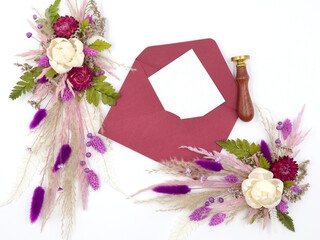 Flatley of natural flowers, envelope and greeting card, seal, top view, white background, space for text. Decor. High quality photo