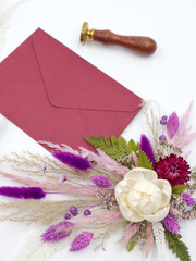 Flatley with natural flowers, envelope and seal on white background, top view, decor, welcome card. High quality photo