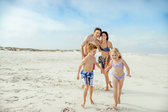 Happy young family on a sandy beach on their summer vacation