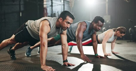 Gym, men and women in floor exercise for strong body, muscle development and balance power. Commitment, motivation and fitness team with personal trainer, training with focus and workout mindset.