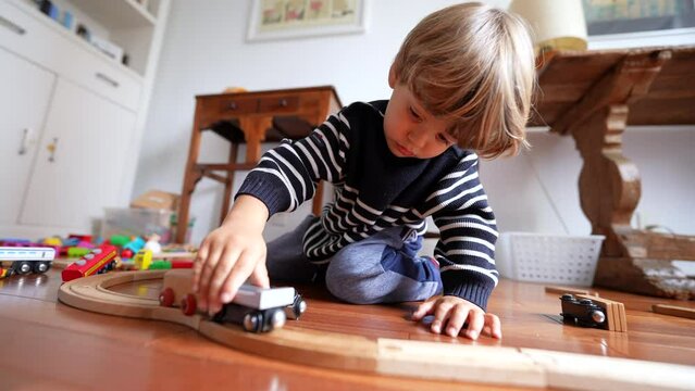 Boy Playing with Vintage Train Set at Home, Close-up of Kid's Hand with Retro Toy Railroad