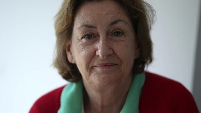 Portrait of a senior woman smiling at camera, close-up face of an elderly lady with friendly expression, traditional grandmother