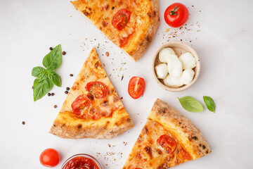 Pieces of tasty pizza Margarita with basil and bowl of mozzarella on white background