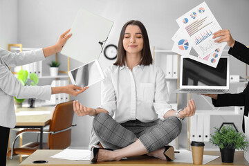 Young businesswoman with a lot of work meditating in office