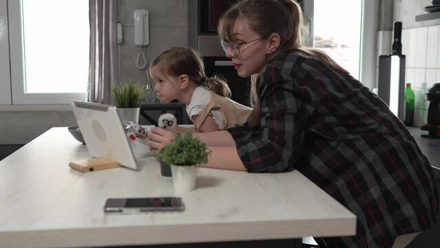 small girl toddler and mother or aunt play with finger puppets at home
