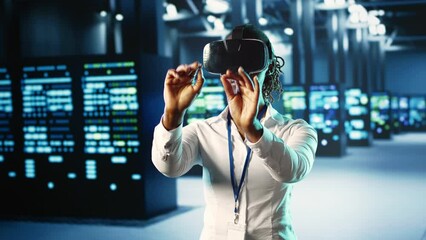 African american woman immersed in virtual reality at data center, doing equipment maintenance. Qualified engineer using VR headset to optimize server equipment performance, checking operations - Powered by Adobe