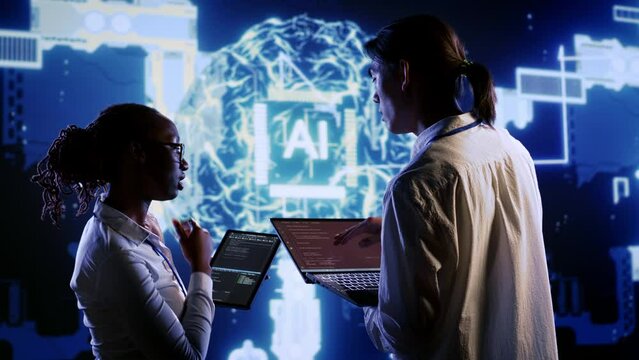 IT team members develop artificial intelligence neural networks architecture inspired by human brain, setting up AI machine learning algorithms using binary language programming on tablet and laptop