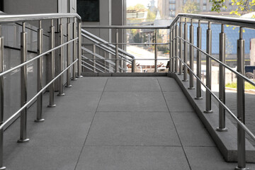 Ramp with metal handrails near building outdoors