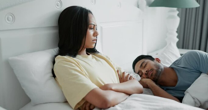 Bed, angry and a woman thinking about divorce with her sleeping husband in the evening while looking sad. Couple, insomnia or breakup with a young wife looking upset while in the bedroom of her home