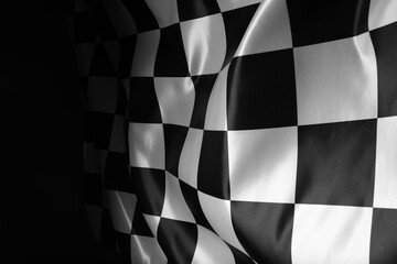 Checkered flag on black background, closeup view