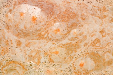 Colorful foam after dissolving bath bomb in water, closeup