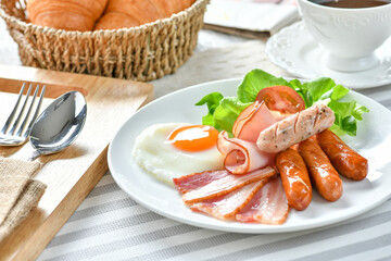American breakfast with sunny side up eggs, bacon, toast, wood background