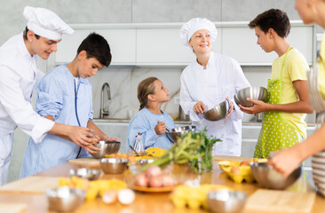 Teenage children are interested in learning in culinary courses under the supervision of two adult chefs
