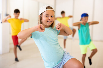 Girl and other kids dancing hip hop in dance studio