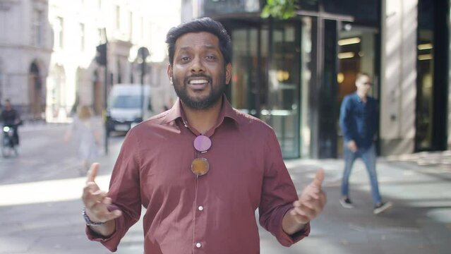 Confident young presenter on the streets talking to camera as he walks