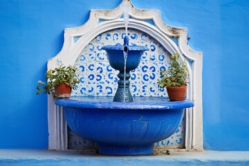 Fountain with drinking water on blue wall in Chefchaouen, Morocco. Generative AI