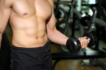 Fototapeta na wymiar Closeup and crop perfect body with weight training at fitness center.