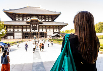 Woman standing and photographing the Todaiji temple, Japan