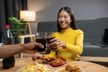 Group of happy asian young people celebrating clinking glasses drinks During a party in the living room of the home office Christmas or New Year's party lifestyle concept, study, work, holiday.