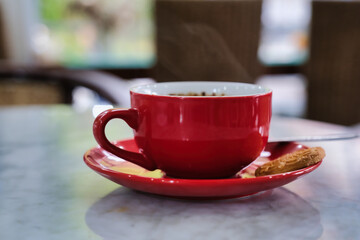 A cup of black coffee and a piece of cookie