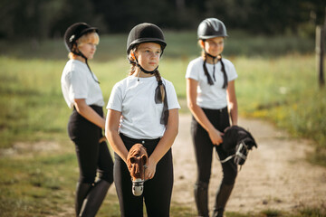 Portrait of a jockey girl who sits on a toy horse.