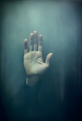 blurry hand of a man with a sign saying hold, book cover , story telling concept