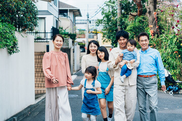 笑顔で外を散歩する3世代のファミリー