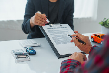 Businessman completes successful car purchase transaction by gifting car keys after finalizing...