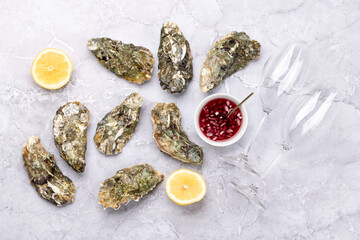 Fresh oysters with sauce and lemons