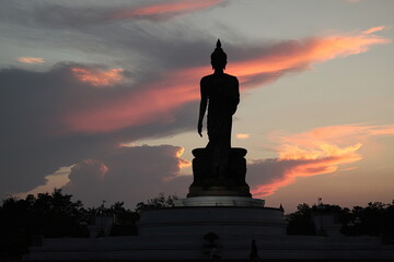 Shadow of Buddha statue and clouds at sunset.