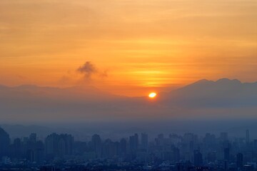 Fototapeta premium Sunrise over Taichung City with Mountains in the Background