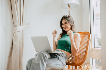 young woman with laptop computer at home happy cheerful success win positive expression
