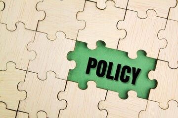 wooden puzzle with the word policy. basic concepts or organizational policies. a course or principle of action adopted. term concept