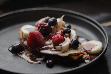 Rich sweet cream, with fruit on a black plate
