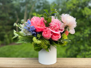 Bouquet colorful flowers in white vase in spring garden.