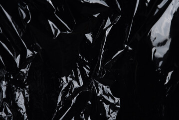 Transparent plastic wrap on the black background. Plastic bag texture