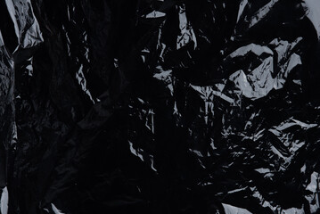 Transparent plastic wrap on the black background. Plastic bag texture