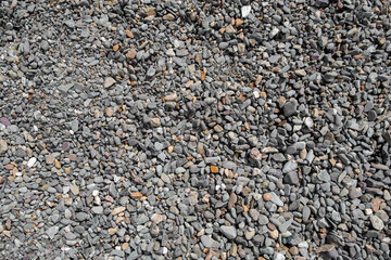 The stones were laid on the ground in the garden as a background. Background blur. Pebble stones background. Crushed stone on the seashore. Selective focus on object. 