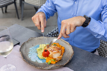 Chicken fillet with potato and carrot puree on a plate, ready to be enjoyed with a fork in hand