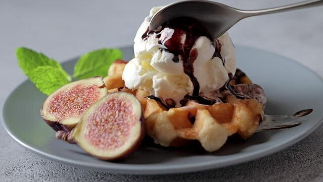 Footage of eating summer dessert with vanilla ice cream, waffles, and fig fruits.