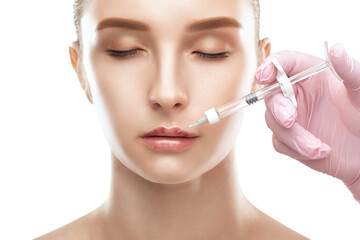 Cosmetologist does injections for lips augmentation anti wrinkle injections on the face of a...