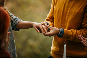 The joyous ambiance of a garden party, with a couple proposal with a diverse group of people relishing a shared meal amidst nature's beauty.