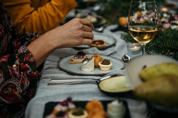 The joyous ambiance of a starter food, with a diverse group of people relishing a shared meal amidst nature's beauty